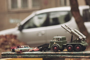 Soviet military toy cars on a bench on the street.