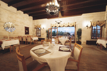 Fototapeta na wymiar traditional spacious interior of modern empty large restaurant with tables and chairs