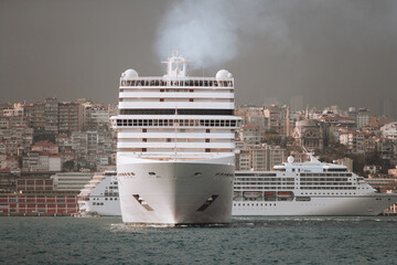 a large sea passenger liner departs from the shore for a trip.