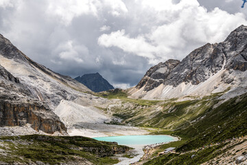 Panoramic view of the scared milk lake, also called niunai lake at a high altitude in Yading, Daocheng, Si Chuan Province. Glacier lake in China, copy space for text, dramatic sky