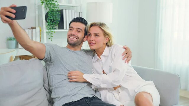 Caucasian young couple spend free leisure time together in living room. 