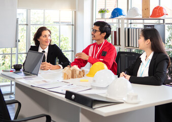Construction business meeting : engineer and architect teamwork sitting in office working on building project discussion. Multiracial business person talking brainstorming idea in project development.