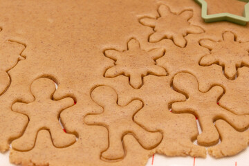 Background rolls out the dough with cookie cutters at the kitchen