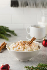  Scandinavian rice porridge with cinnamon in a bowl surrounded by Christmas balls. Breakfast on...