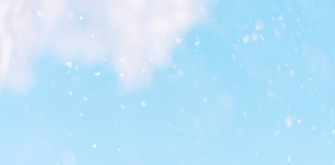 Background of falling snow against the blue sky.