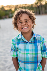 Charming Beautiful Black young boy with a playful smile and curly hair. Outdoor candid portrait of a natural beauty