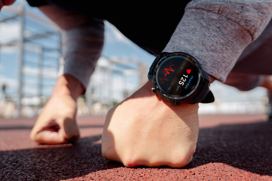 man sports a smartwatch. the guy does push-ups at the stadium. An application for heartbeat monitoring on a smart watch . Fat burning for weight loss. all the graphics on the screen are made up.