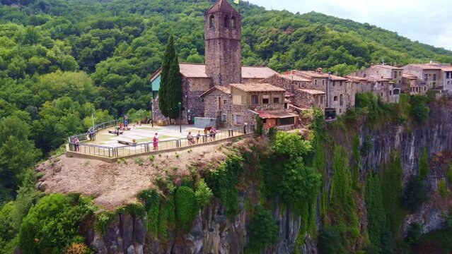 Flying away from a church, and the view point in Castellfollit de la Roca, typical village in Catalonia, Spain