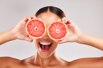 Face, skincare and grapefruit in woman hands in studio portrait for facial eco friendly, vegan or healthy product marketing or advertising space. Happy model with vitamin c fruits for skin care glow