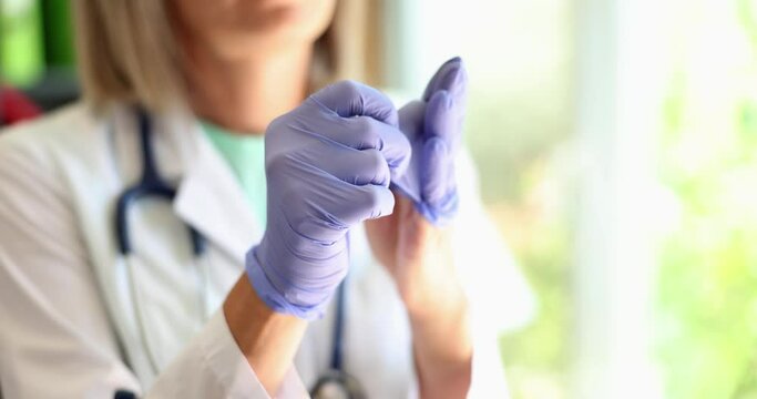 Doctor removes disposable medical gloves in clinic