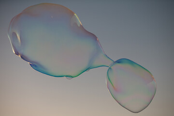 Soap bubbles with rainbow reflection. Buble at the blue sky. Bubble party.