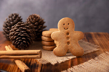 Obraz na płótnie Canvas Homemade gingerbread man cookie and pinecones, cookies traditionally made at Christmas and the holidays.