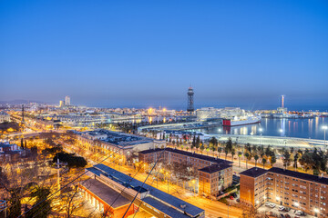Naklejka premium The skyline of Barcelona with parts of the harbour at dusk
