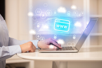 Hands working on laptop with digital icons