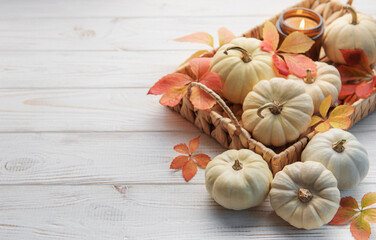 Autumn leaves and pumpkins over old wooden background