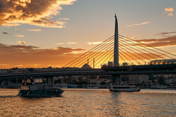 Fototapeta na wymiar A large bridge across the river in the sunset rays of the sun. The silhouette of the bridge.