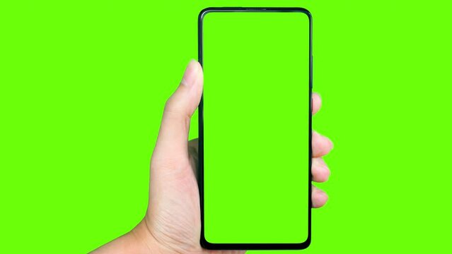 Business man hand shows mobile smartphone with green screen on green background.	