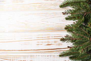 Christmas background with fir branches, pinecones, on the old white wooden board. Top view.