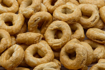 Taralli alla pugliese with extra virgin olive oil background. Traditional italian snack Taralli