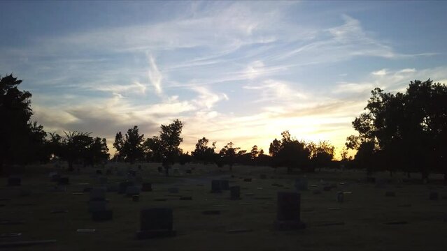 Spooky and haunted view of Cemetery during golden hour. Silhouette. Drone flying low.