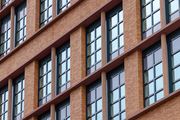 Fototapeta na wymiar Fragment og facade of brick building with windows, minimalism.