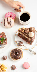 Table with various cookies, donuts, cakes,  coffee cups on white  background.