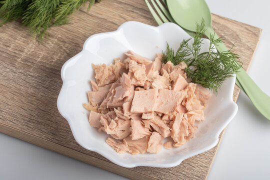 canned tuna in white plate on wooden background