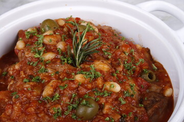 Lamb shoulder chops braised with tomatoes, beans, carrots and olives