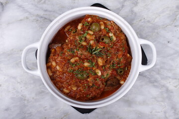 Lamb shoulder chops braised with tomatoes, beans, carrots and olives