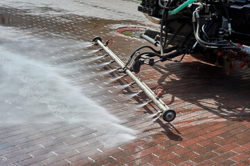 A special machine washes city paths and roads with water