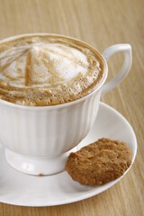 Coffee with milk froth and cookie
