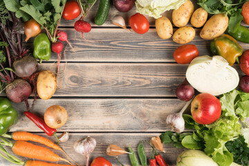 Colorful mix of fresh farm vegetables and fruits, top view. Table full of organic ripe seasonal...