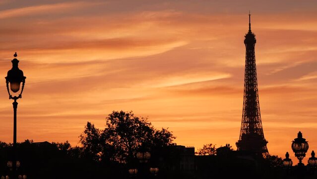 4K video with an amazing sunset in Paris. The silhouette of Eiffel Tower landmark against beautiful sunset sky in France.