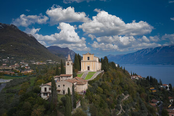 Fototapeta na wymiar The parish church of San Michele Arcangelo is located on a hill overlooking Lake Garda, Italy. Panoramic aerial view of the Church of San Michele Arcangelo.