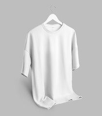 Mockup of an oversized white t-shirt with a round neckline hanging on a hanger with the bottom...