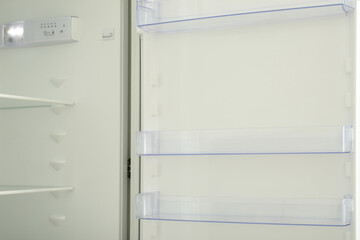 Empty shelves of empty modern white fridge