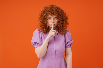 White ginger woman with curly hair showing silence gesture