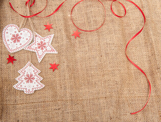 Wooden Christmas decorations with tinsel on a background of burlap with artificial snow