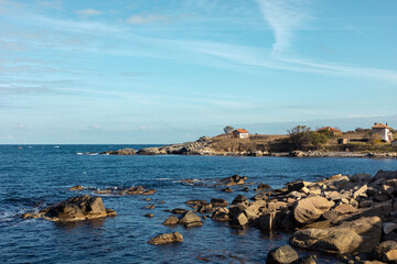 Rocks on the sea coast. The landscape of the sea bank. Stones in the water.