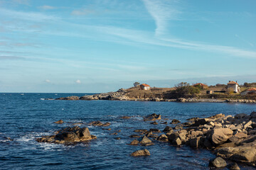 Fototapeta na wymiar Rocks on the sea coast. The landscape of the sea bank. Stones in the water.