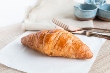 French croissant on the grey wooden table decorated with napkin.