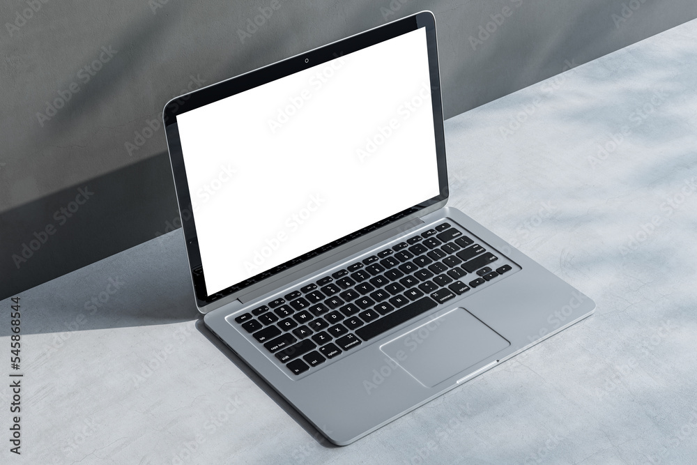 Poster perspective view on blank white laptop screen with space for your logo or text on light concrete sur