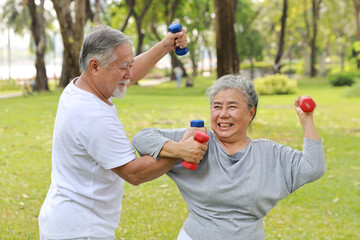 Happy and smiling asian senior couple doing arm work out and lifting dumbbell exercise with...