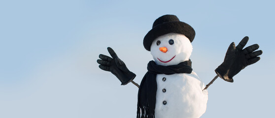 Fashion snowman in black hat, scarf and gloves. Close up face of snowman on the winter background....