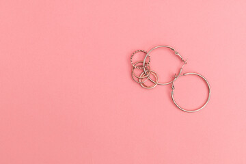 Silver costume jewelry on a delicate pink background, advertising shoot