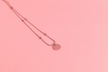 Silver costume jewelry on a delicate pink background, advertising shoot