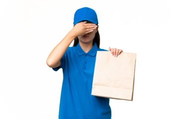 Young Asian woman taking a bag of takeaway food over isolated background covering eyes by hands. Do not want to see something