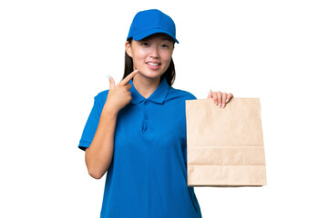 Young Asian woman taking a bag of takeaway food over isolated background giving a thumbs up gesture