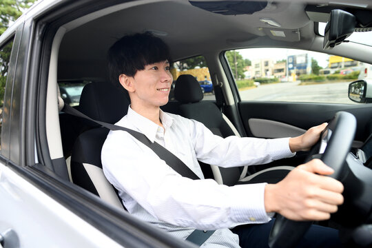 笑顔で運転をする若いアジア人男性
