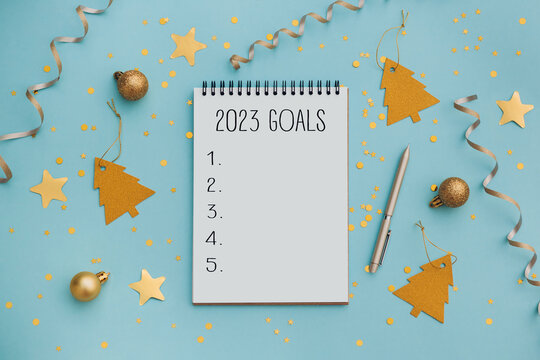 New Year goals List 2021 with notebook written in handwriting about plan listing of new year goals and resolutions setting. flat lay style. Christmas planning concept.